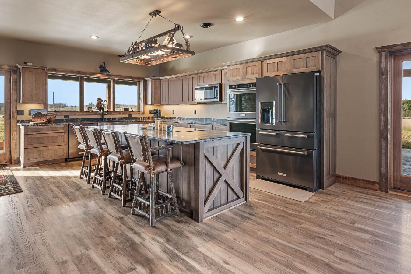 This spacious kitchen features custom cabinetry, a large island with seating, and high-end stainless steel appliances, perfect for entertaining.