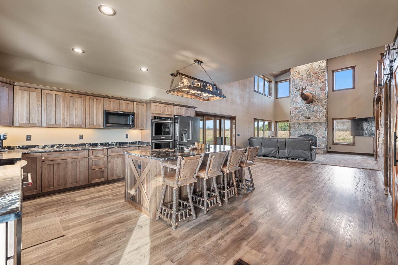 The open floor plan seamlessly connects the kitchen, dining, and living spaces, highlighted by natural light and rustic accents.