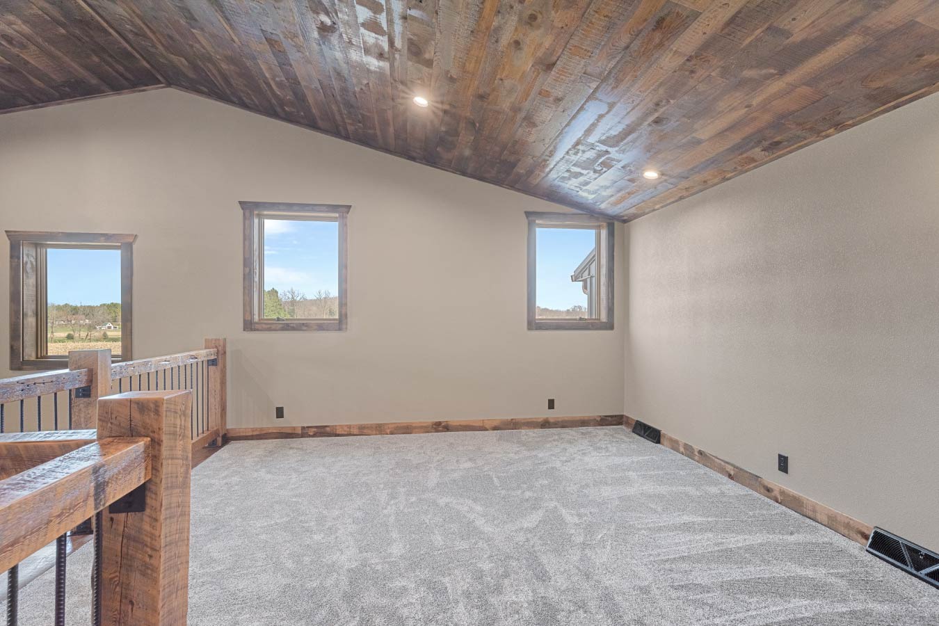 A versatile loft space with vaulted wooden ceilings and panoramic windows.