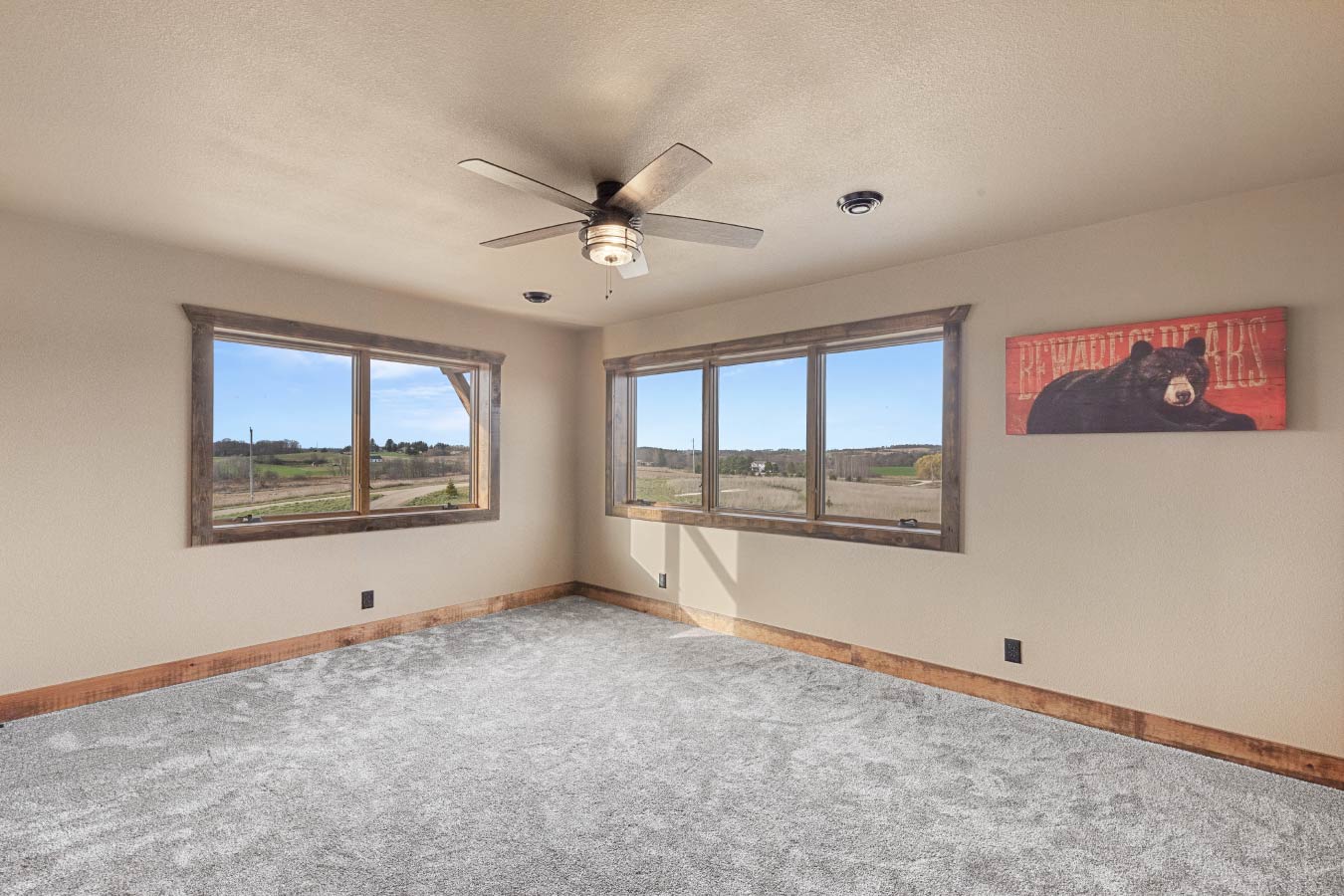 A bright and airy secondary bedroom with large windows offering sweeping views of the countryside.