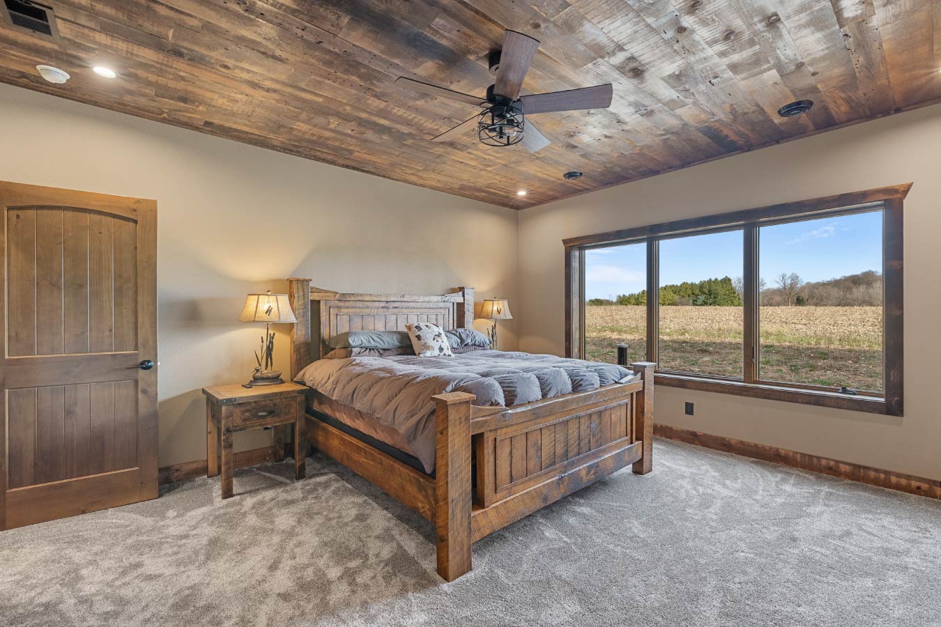 A rustic master bedroom with a comfortable wooden bed and matching furniture.