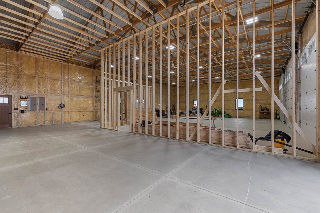 The spacious workshop in the Barndominium with Workshop is designed for versatility and future upgrades. This area will include a custom bar and state-of-the-art indoor golf simulator, making it the ultimate multipurpose space for work and play.